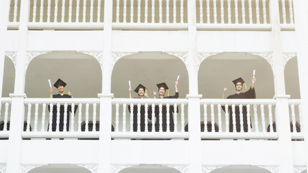 people students  in the feeling of happy and graceful with the graduation gowns and cap stand in the line at corridor of classic building.の写真素材