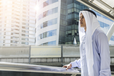 Arab man stands and look forward at outdoor city space at morning dayの写真素材