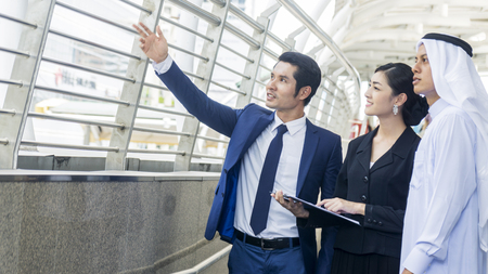Smart asian arab business people man and woman worker talk and joy together in the situation of look forward future idea at the pedestrian walkwayの写真素材