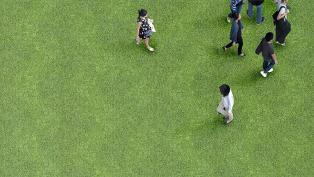 man and women people walk on across grass greenfield landscape background in the garden park (Aerial top view)の写真素材