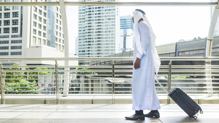arab man carry a suitcase at business cityの写真素材