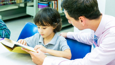 teacher and boy student learn with book with bookshelf background