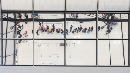 reflection glass of top view people in line queue with luggage and briefcase to travel at airportの写真素材