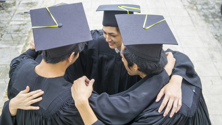 people with black gowns hug neck in groupingの写真素材