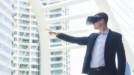 businessman with vr glass for smartphone stand at outdoorの写真素材