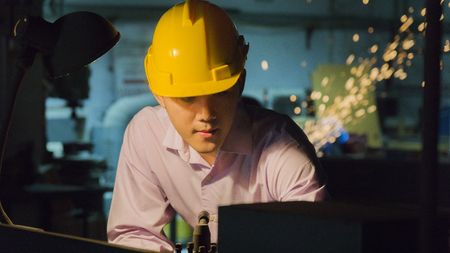 worker use bending machine with steel pipe. Metal working concept in low lightの写真素材
