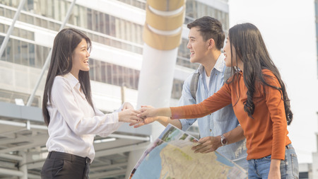 traveler couple people use generic local map and talk with adviser business woman. Honeymoon trip, holiday vacation travel concept.の写真素材