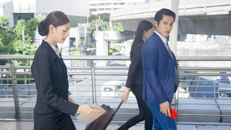 group smart business people of man and woman walk together in rush hour in feeling stress  with tablet smart phone device and luggage at the outdoor pedestrian walkway space in the morning.の写真素材