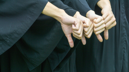 people with black graduation gowns thump downの写真素材