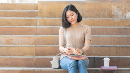 student teen girl with education book and coffee cup sit on stair pedestrian