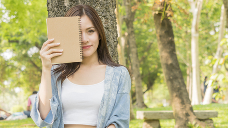fashion girl use a book and hold in hand show front of faceの写真素材