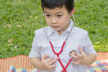 boy use stethoscopes and feel happy in garden parkの写真素材