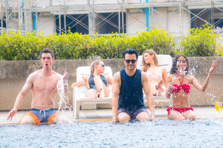 sexy people on swimming wear sitting at pool water enjoying vacation