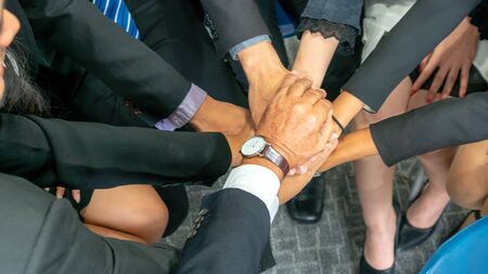 top view of young people showing their hands on top of each other. Group of businessman making a stack of hands with copy space.の写真素材
