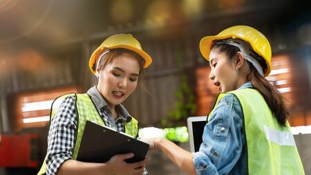 Professional engineering woman worker walk and check in warehouse factory. Manager discuss inspection report paper for internal audit. Quality assurance for manufacturing industry. Concept Engineer Operating with safety.の写真素材