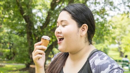 fat girl eat ice cream in close up face feeling deliciousの写真素材