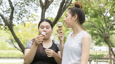 two people fat and cute girl eat ice cream with feeling deliciousの写真素材