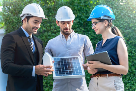 Business Engineers Meeting Innovative More Efficient Solar Panel Battery Concept of Renewable Energy Working. Specialists Gathered for Outdoor testing Photovoltaic cells module.の写真素材