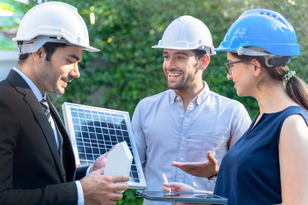 Business Engineers Meeting Innovative More Efficient Solar Panel Battery Concept of Renewable Energy Working. Specialists Gathered for Outdoor testing Photovoltaic cells module.の写真素材