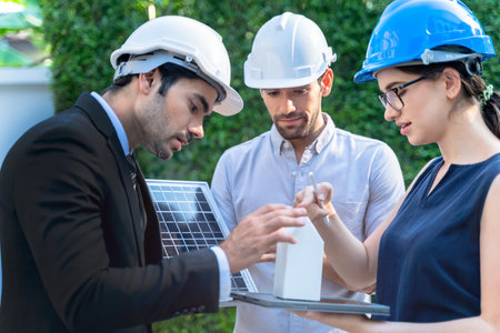 Business Engineers Meeting Innovative More Efficient Solar Panel Battery Concept of Renewable Energy Working. Specialists Gathered for Outdoor testing Photovoltaic cells module.の写真素材