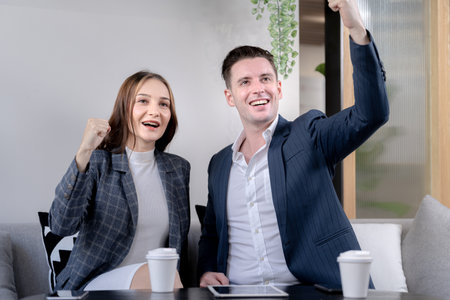 business man and woman hand up and laughing in feeling happy. Successful company achieving goals with determined staffの写真素材