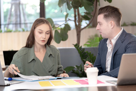Two professional business people working together in office. Indoor biophilia and nature trees environment.の写真素材