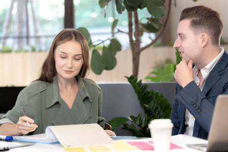 Two professional business people working together in office. Indoor biophilia and nature trees environment.の写真素材