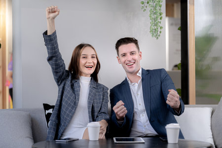 business man and woman hand up and laughing in feeling happy. Successful company achieving goals with determined staffの写真素材
