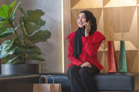 happy face muslim woman in red dress with shopping bag. Concept people activity in shopping festival season christmas and new year.の写真素材