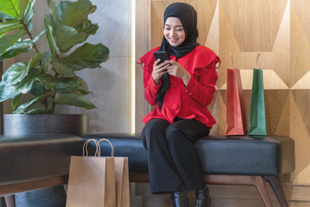 happy face muslim woman in red dress with shopping bag. Concept people activity in shopping festival season christmas and new year.の写真素材