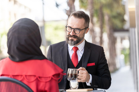 senior man in smart business suit talking to people and sitting in outdoor coffee table.の写真素材