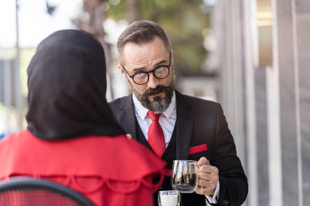 senior man in smart business suit talking to people and sitting in outdoor coffee table.の写真素材