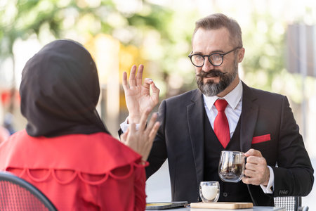 senior man in smart business suit talking to people and sitting in outdoor coffee table.の写真素材