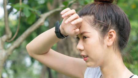 Asian cute healthy fit and firm slim teen lady tired use hand touch her head.の写真素材