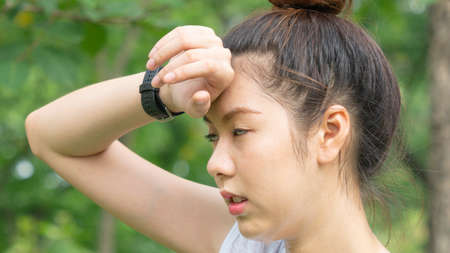 Asian cute healthy fit and firm slim teen lady tired use hand touch her head.の写真素材