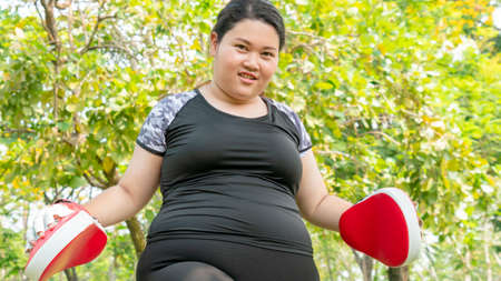 Fat woman dieting training warm up and boxing at outdoor park garden.の写真素材