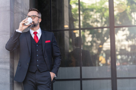 man in business suit holding cup of coffee. business lifestyle in coffee time at morning daylight.man feeling fresh and happy with confident of success.の写真素材