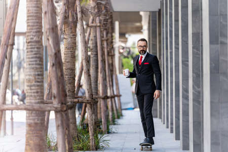man in business suit holding cup of coffee. business lifestyle in coffee time at morning daylight.man feeling fresh and happy with confident of success.の写真素材