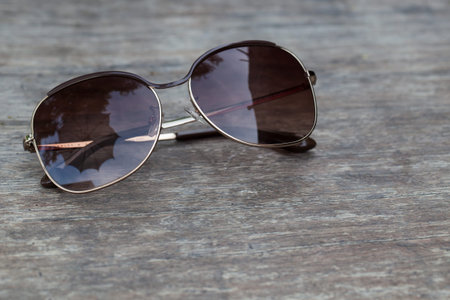 brown sunglasses on old wooden table.の写真素材
