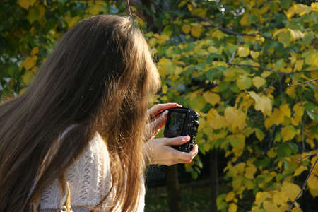A young girl takes pictures nature a compact cameraの写真素材