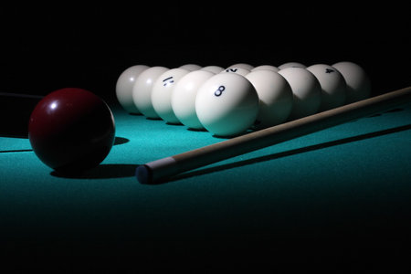 Pool balls on light beam. Balls pyramid with number 8 ball on a foreground.