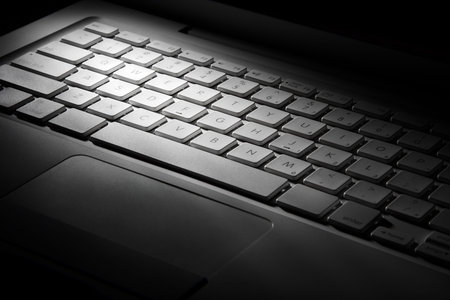 White laptop keyboard in light beam. Simplicity scene in 