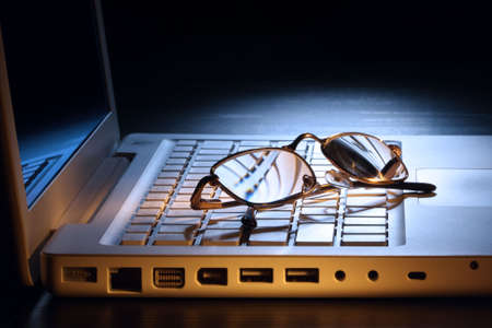 Still life - laptop and glasses on it. Low Key scene.の写真素材