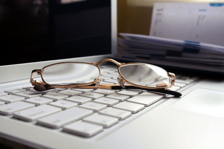 Still life - white laptop with glasses. Diary on background.の写真素材
