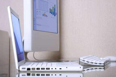 Modern elegance white laptop and computer screen on a glass desk.の写真素材