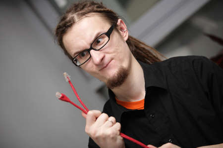 discouraged young man looks at a red patch cordの写真素材