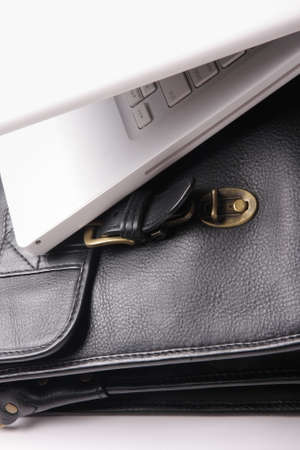 White laptop on a brown brief-case. Nobody.の写真素材