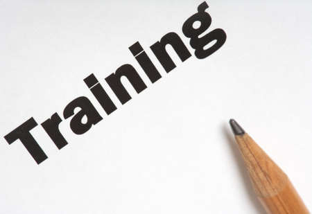 Training. Single word on a white blank paper sheet with pencil. Close-up shot.の写真素材