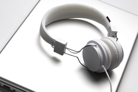 White elegance headphones isolated on an aluminium laptop.