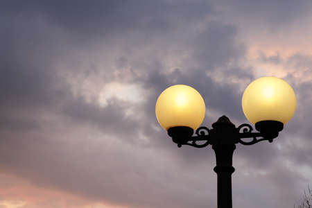 Street lantern lit on a evening dramatic sky background.の写真素材